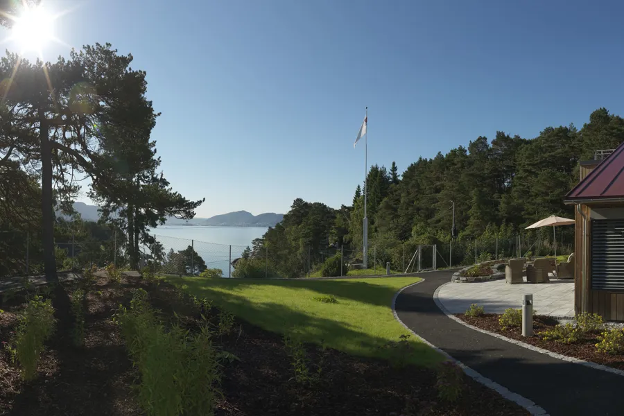 En sti som fører til en bygning og utsikt over sjø